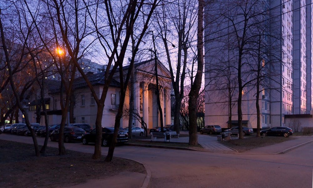 a city street at dusk with a building in the background