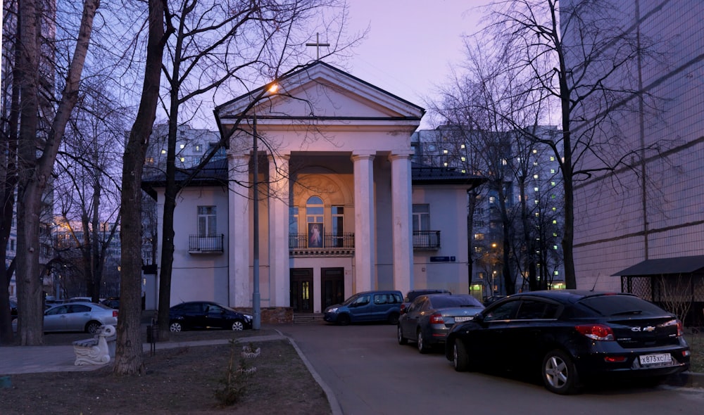 a large white building with a lot of cars parked in front of it