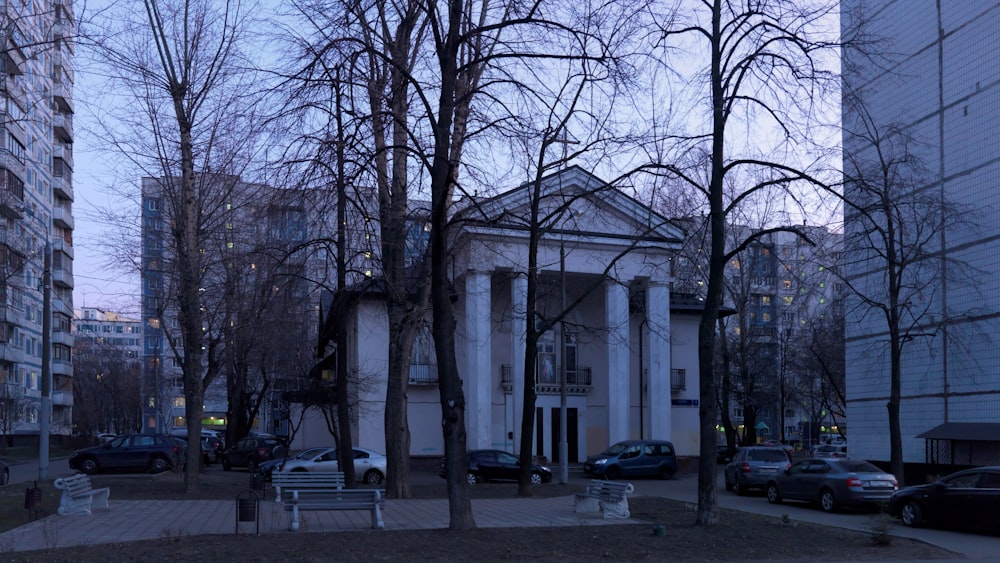 a white building with columns and trees in front of it
