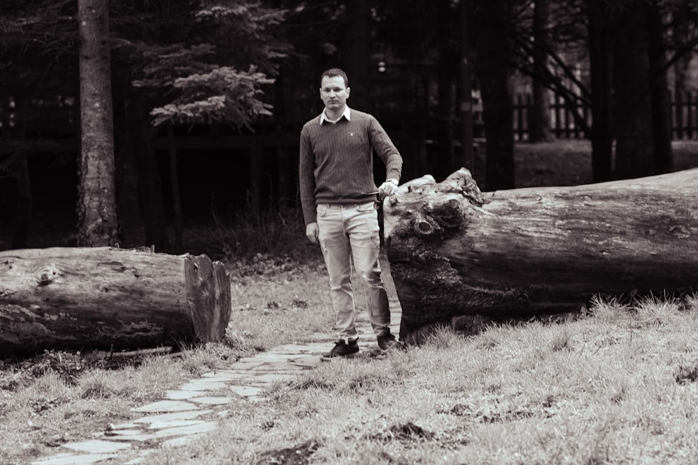 a man standing next to a fallen tree
