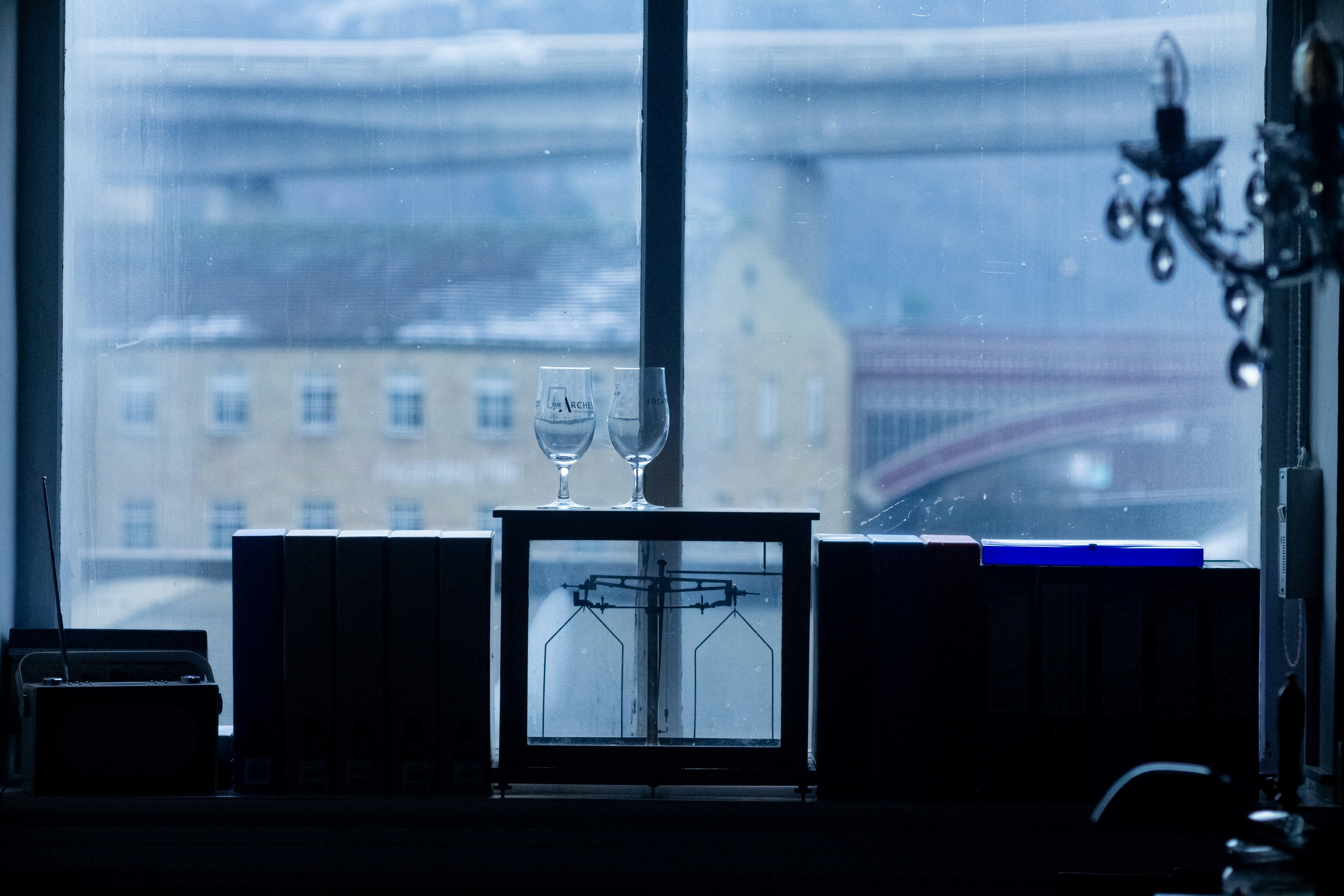 two wine glasses are sitting on a table in front of a window