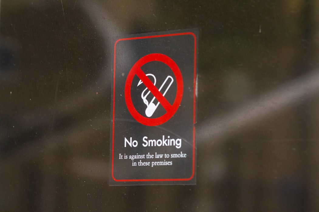 No smoking sign on a glass door - mandatory prohibition sign required in all Malaysian workplaces