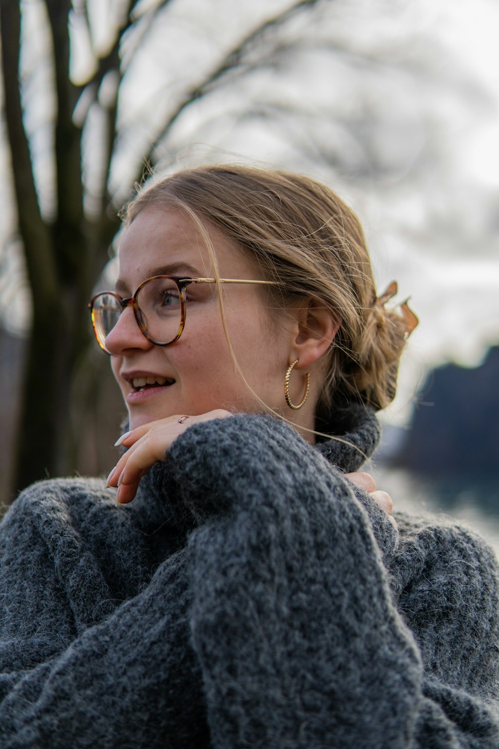 une femme portant des lunettes et un pull gris