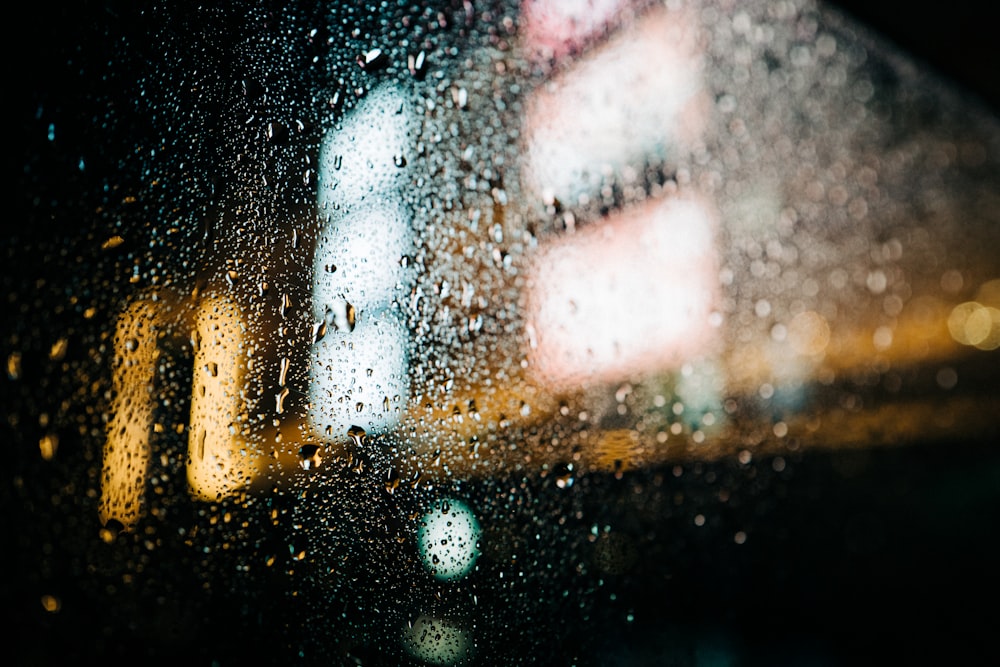 a rain covered window with a building in the background