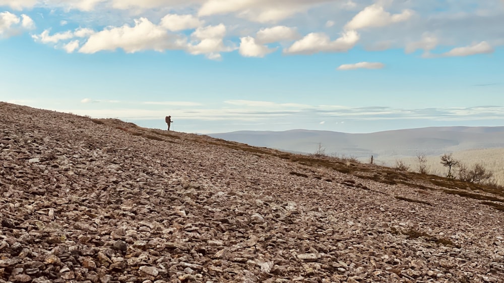 a person standing on top of a rocky hill