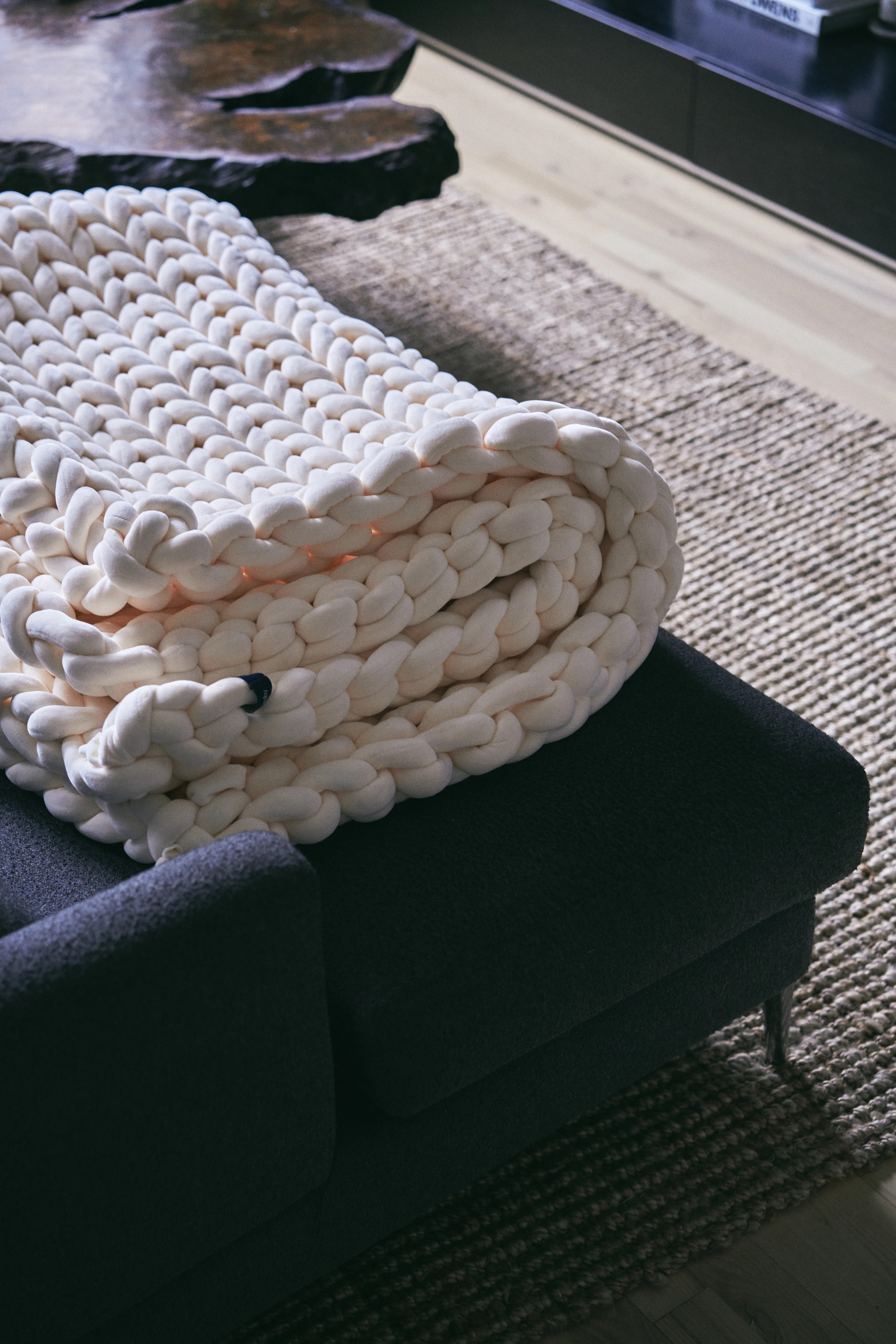 Cream chunky knit throw folded on a bench