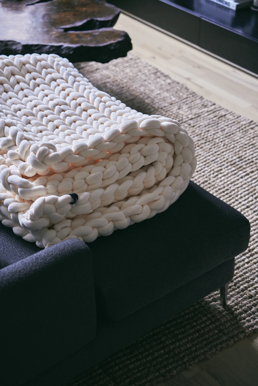 A handwoven wool throw folded on a chair
