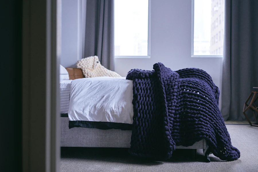 Quarto tranquilo com cama e cobertor ponderado ao lado da janela