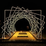 a lighted walkway leading into a dark tunnel