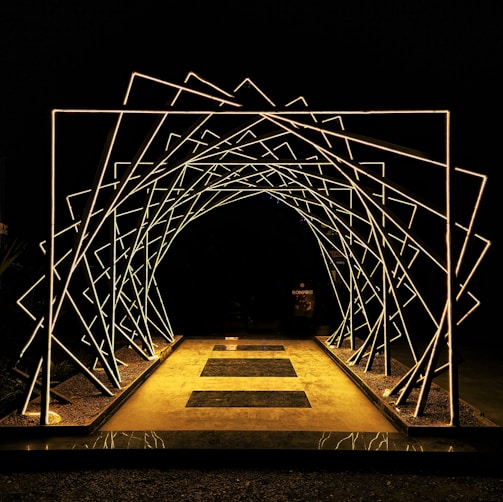 a lighted walkway leading into a dark tunnel