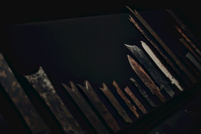 Various specialty blades arranged neatly on a dark surface, ready for sharpening.