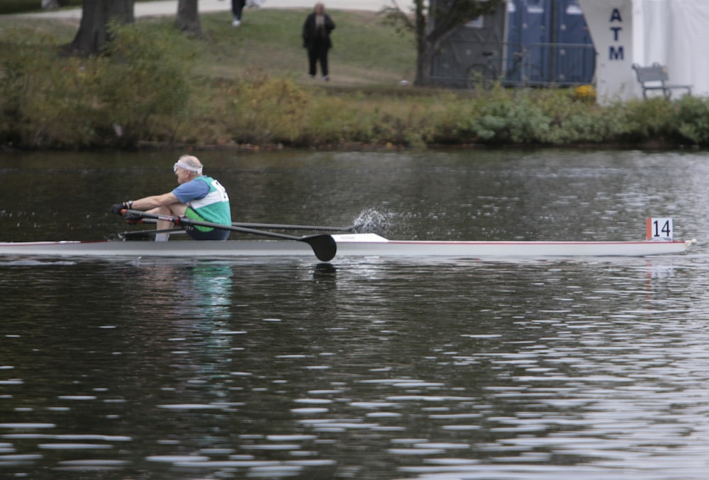 a man rowing a boat on a body of water