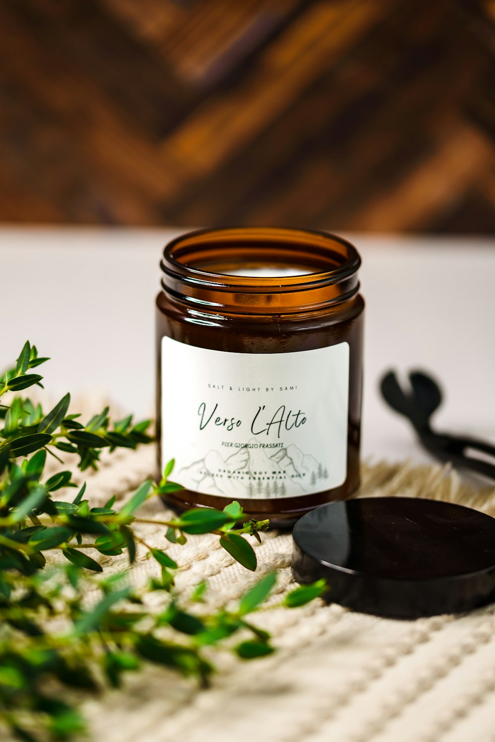 a jar of wax sitting on top of a table next to a plant