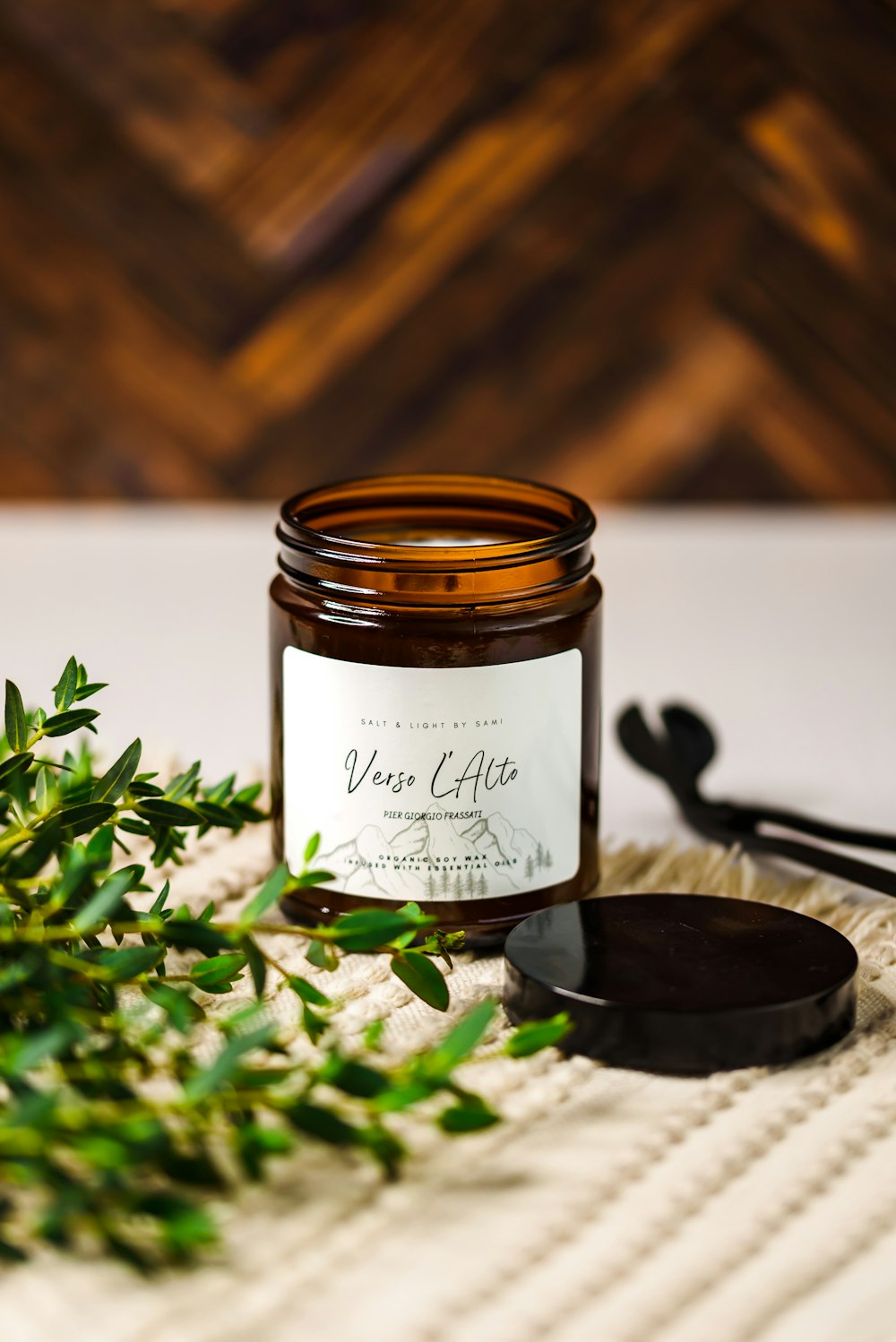 a jar of wax sitting on top of a table next to a plant