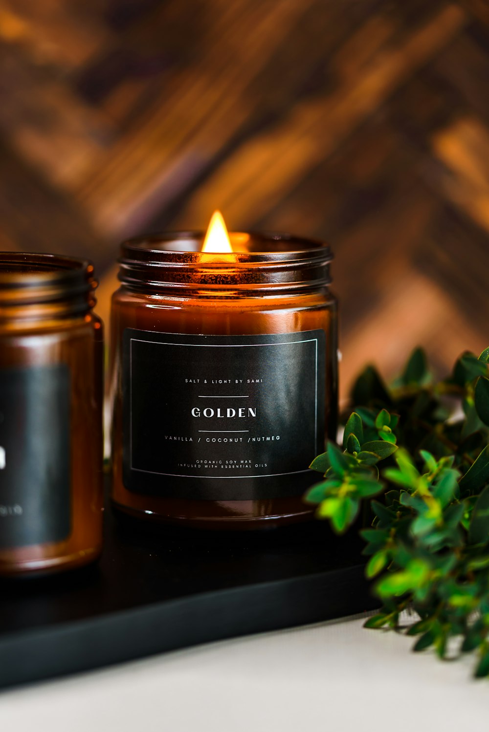 a candle sitting on top of a table next to a plant