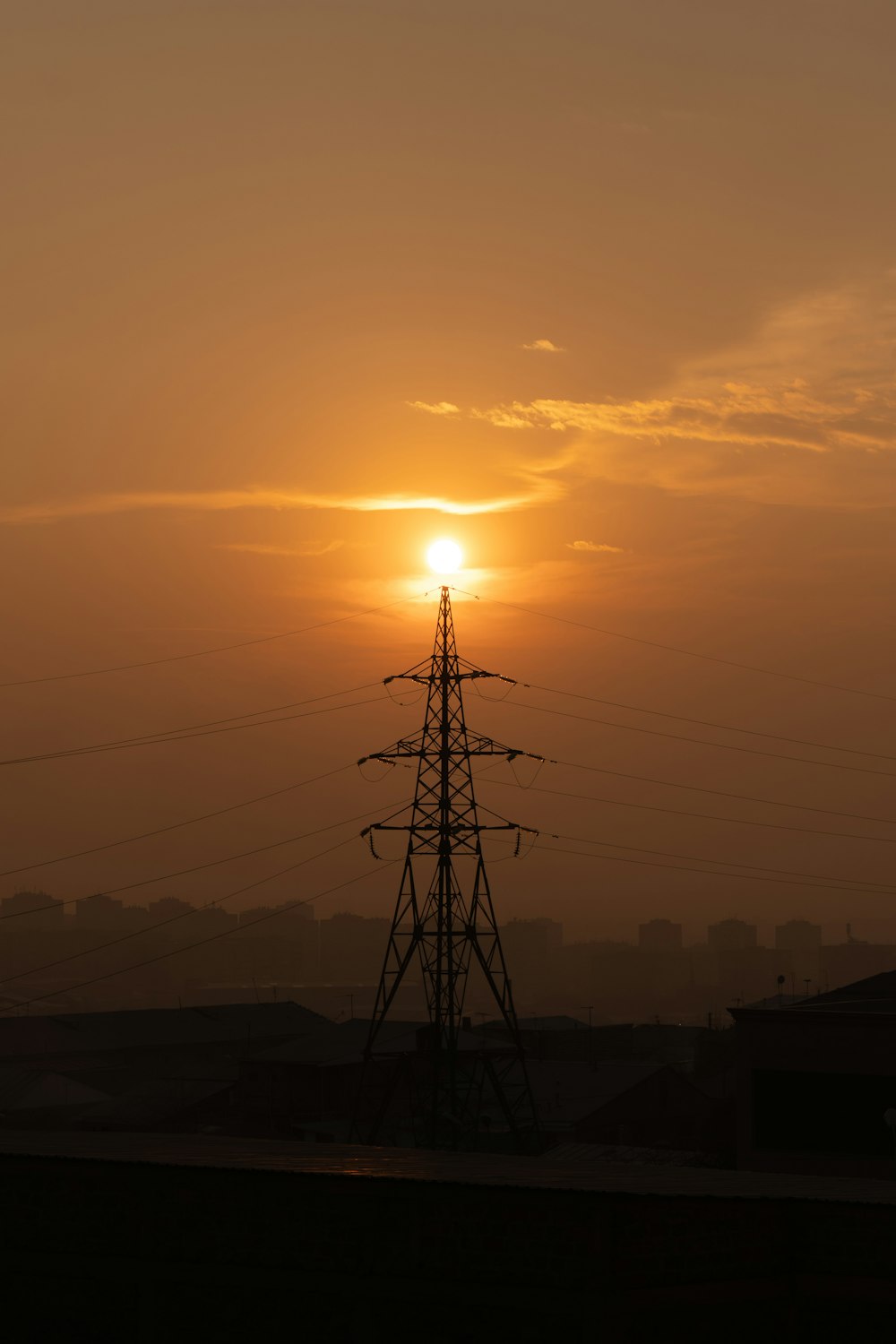 the sun is setting behind the power lines