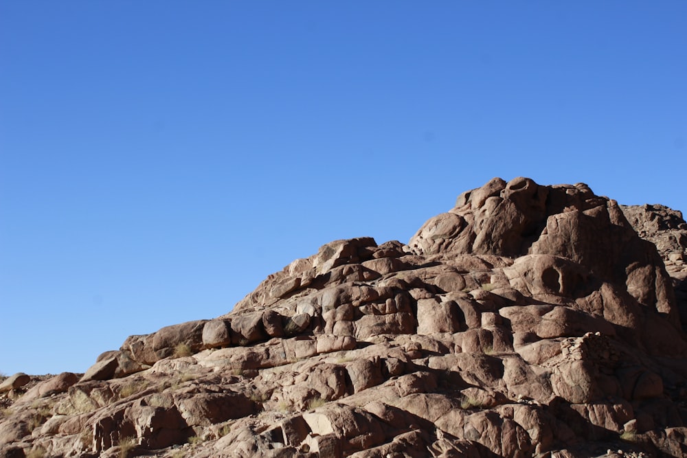 a large rock formation with a clear blue sky in the background