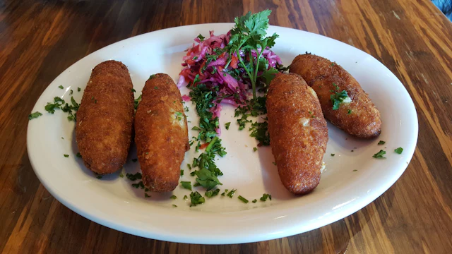 Cuatro croquetas recién fritas en plato blanco