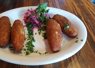 a white plate topped with four fried food items