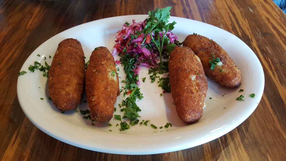 a white plate topped with four fried food items