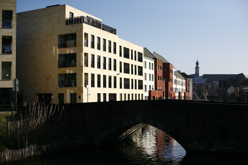 a bridge over a body of water with buildings in the background