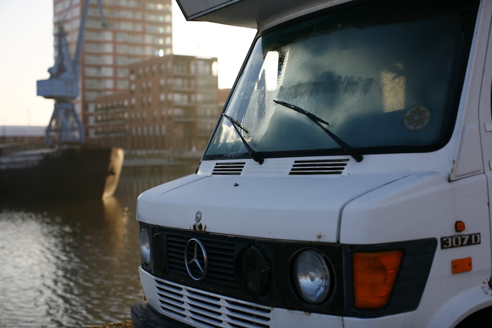 a white truck parked next to a body of water