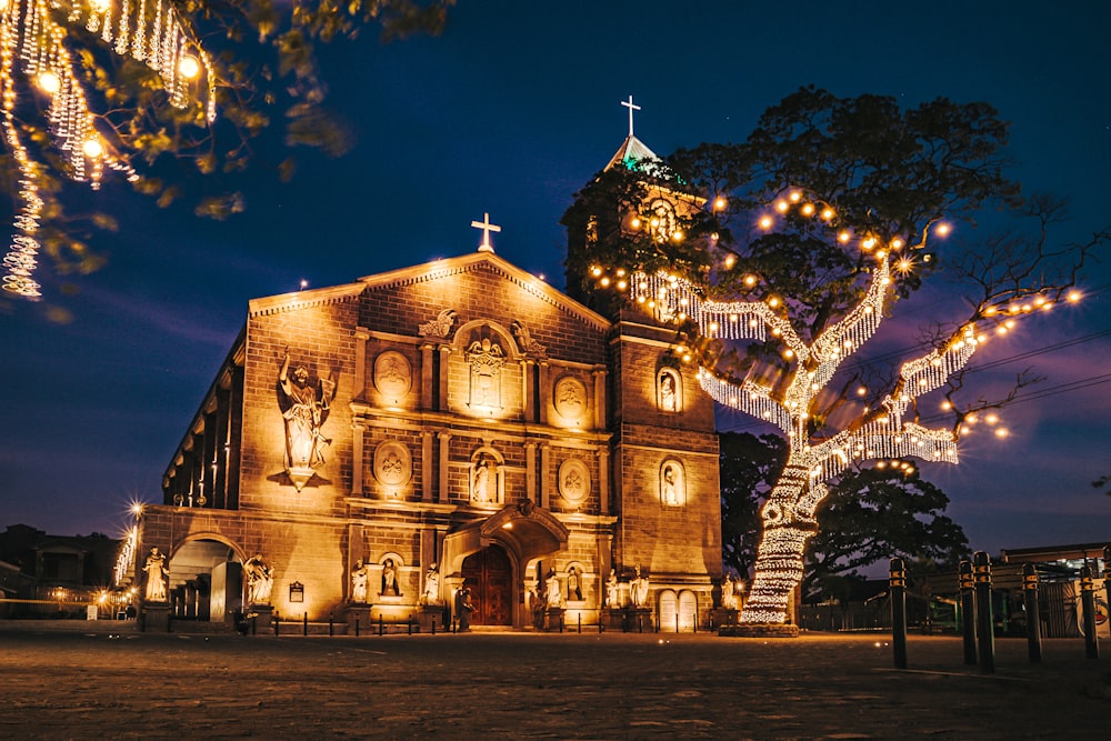 a church lit up at night with christmas lights
