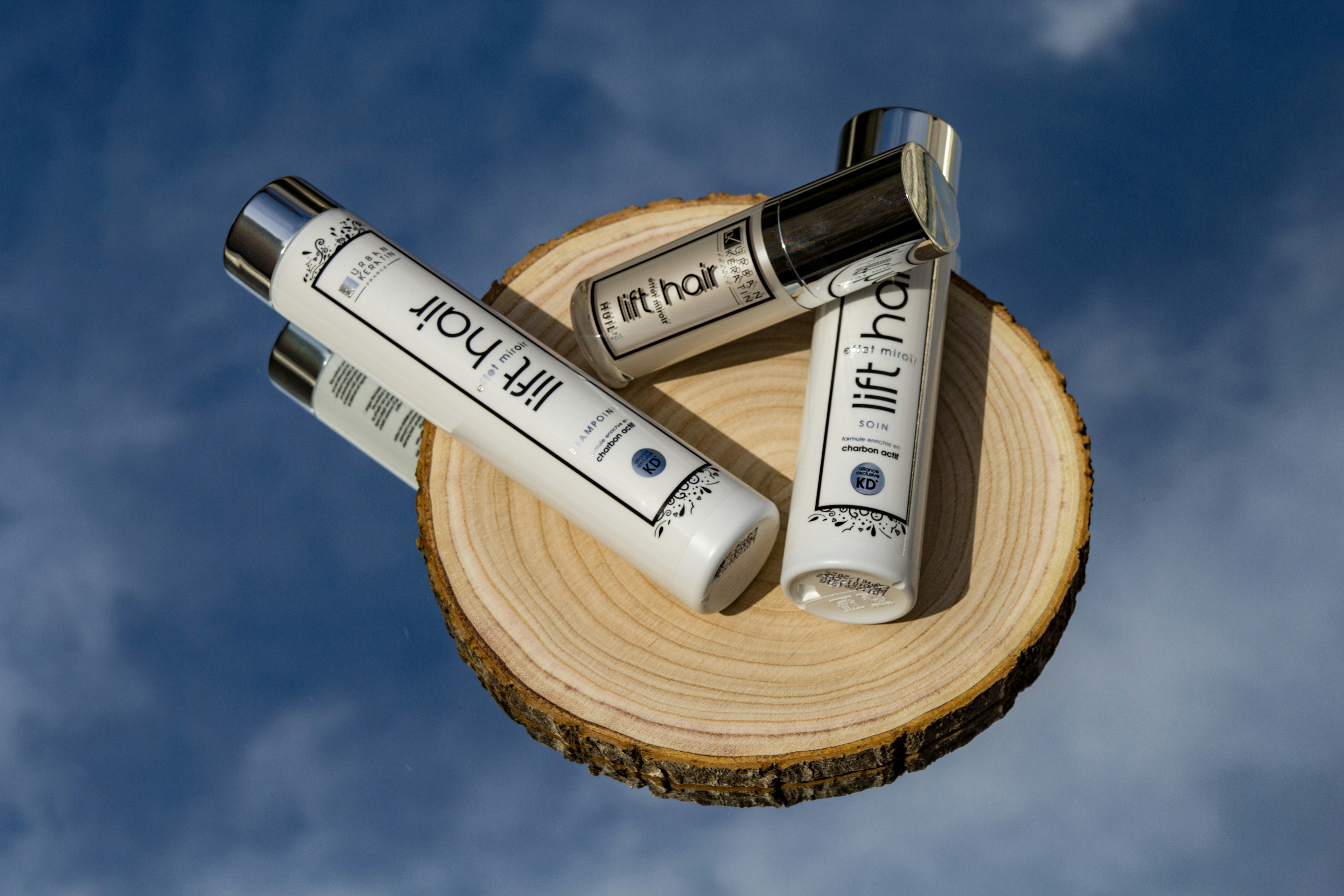 Luxury haircare products on wooden surface with natural light streaming through window