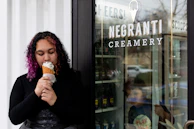 Happy customer enjoying a Gelatoviva ice cream outside a local restaurant