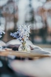 a vase filled with blue flowers sitting on top of a table