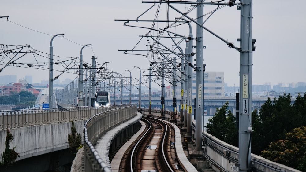 a train traveling down train tracks next to a bridge