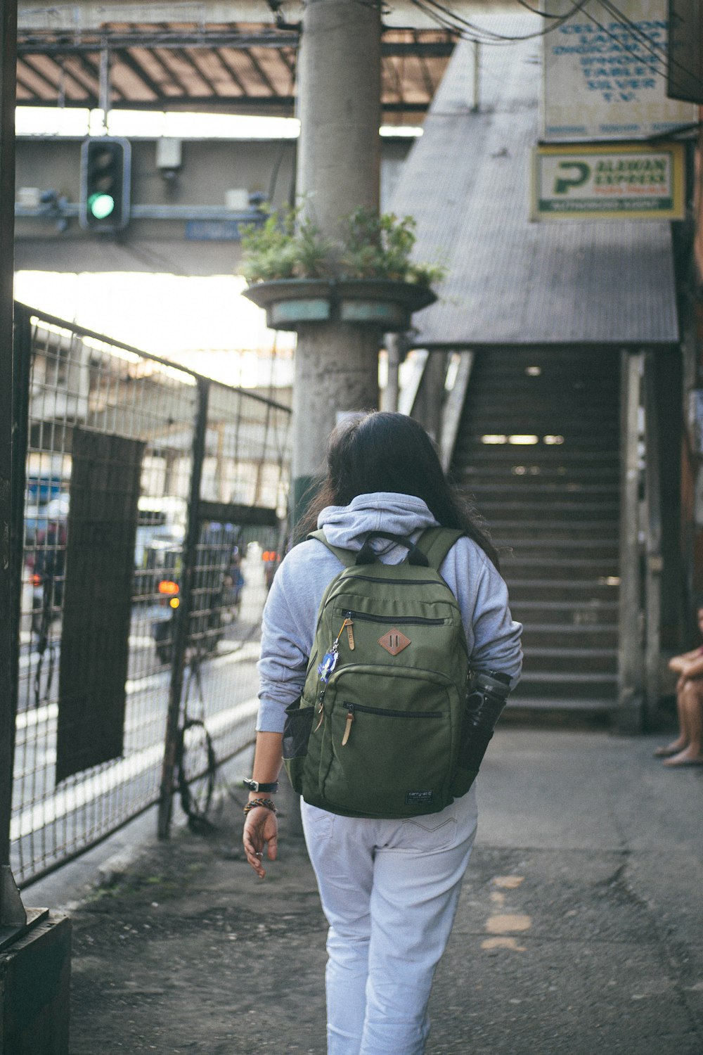 a woman with a backpack walking down a street
