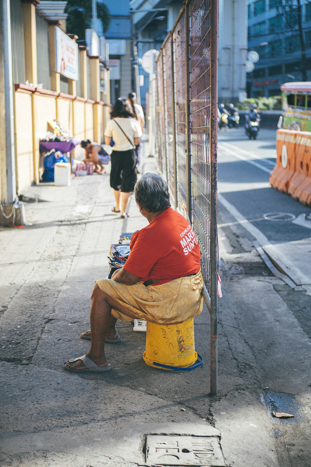 a man sitting on top of a yellow fire hydrant