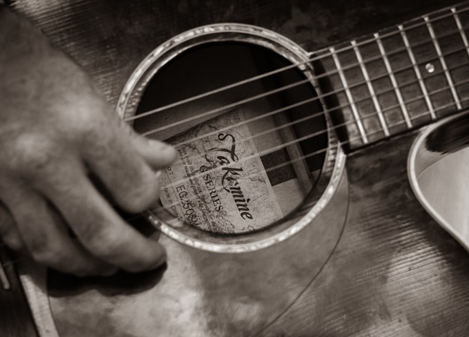 a person playing a guitar with their fingers