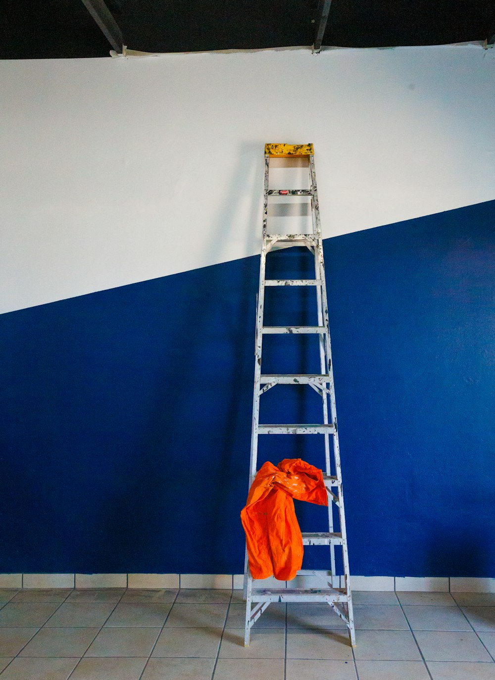 a ladder leaning against a blue and white wall