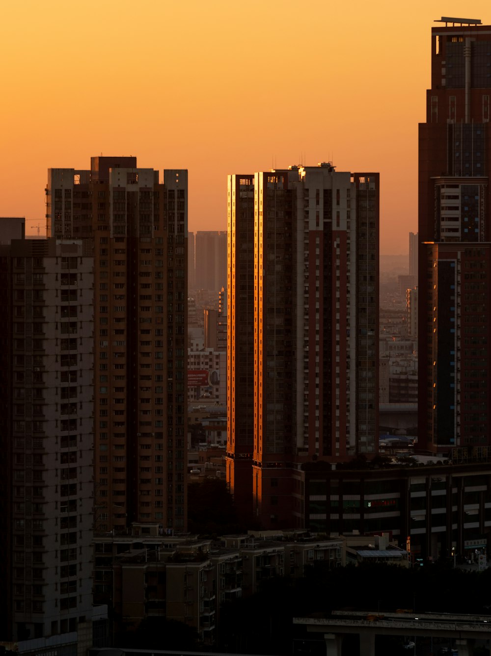 a view of a city with tall buildings at sunset