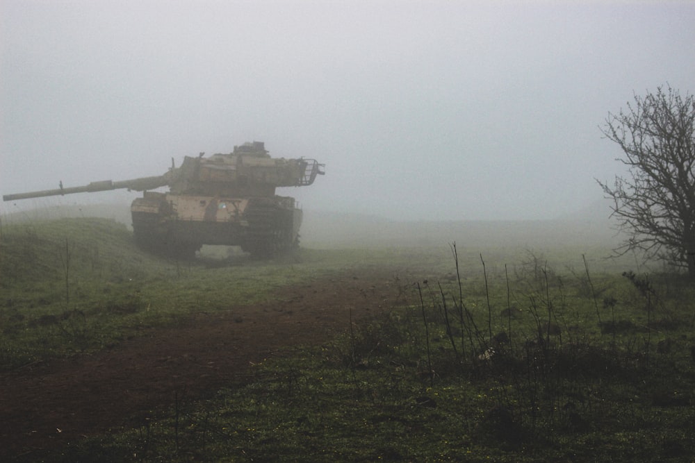 a tank driving through a foggy field