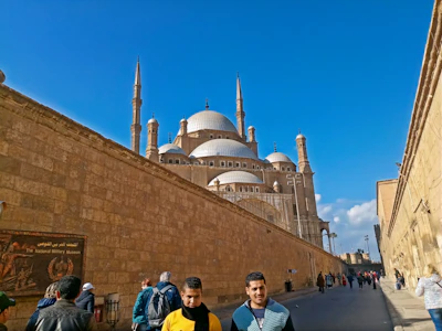 Pilgrims walking towards the Prophet's Mosque in Madinah under a clear blue sky.
