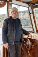 a man standing at the helm of a boat