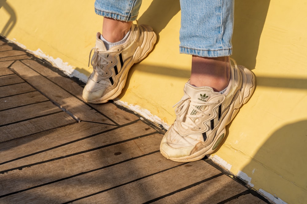 a person standing on top of a wooden floor next to a yellow wall