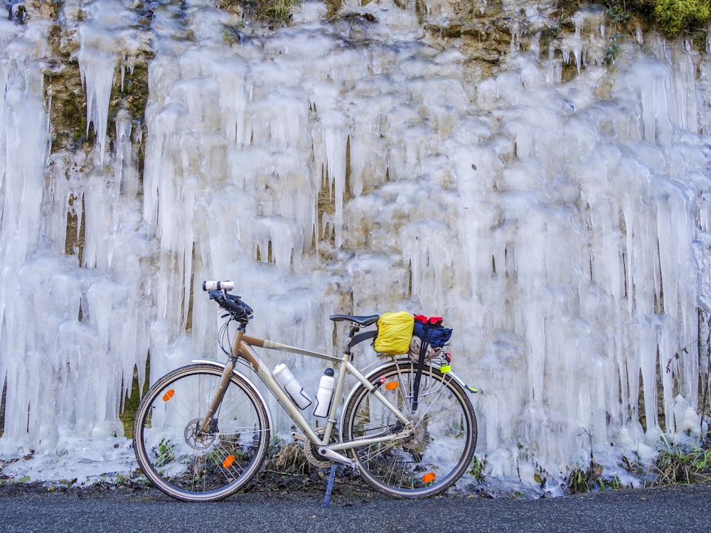 a bicycle parked next to a wall of ice