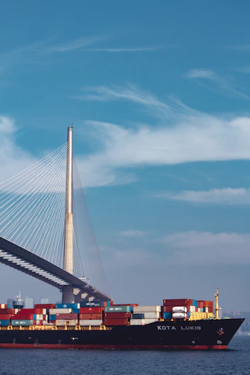 a large cargo ship passing under a bridge