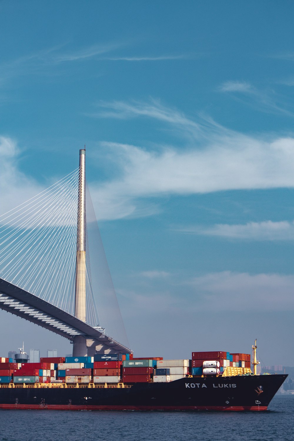 a large cargo ship passing under a bridge