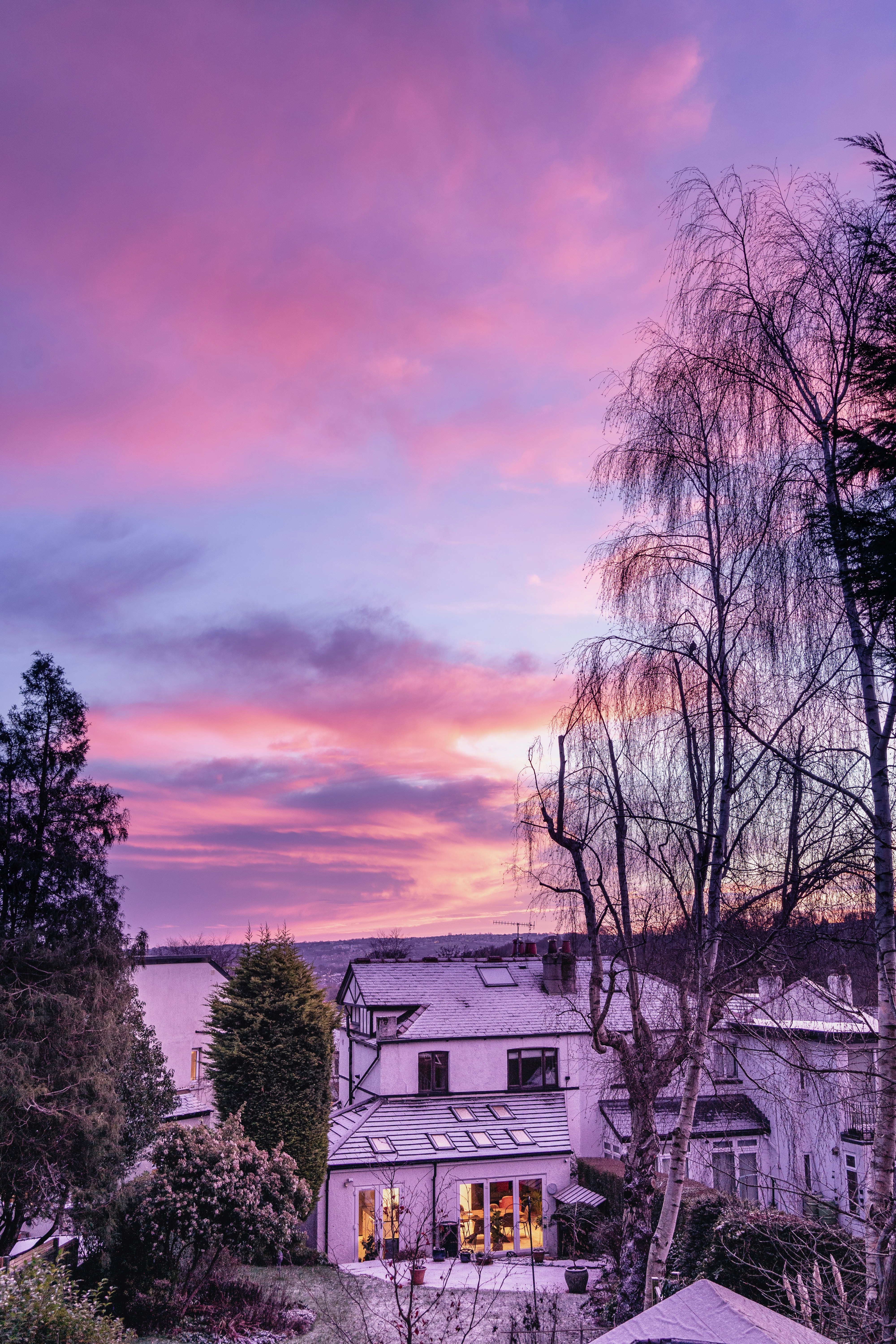 a pink and purple sky over a white house