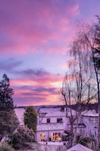 A serene cosmic night sky blending purple and gold hues over a tranquil vastu-inspired home