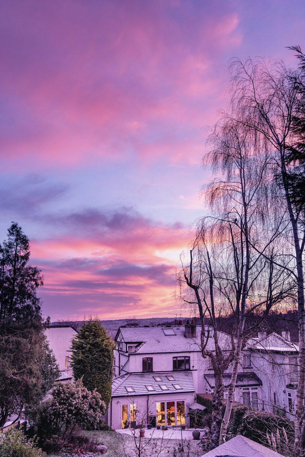 a pink and purple sky over a white house