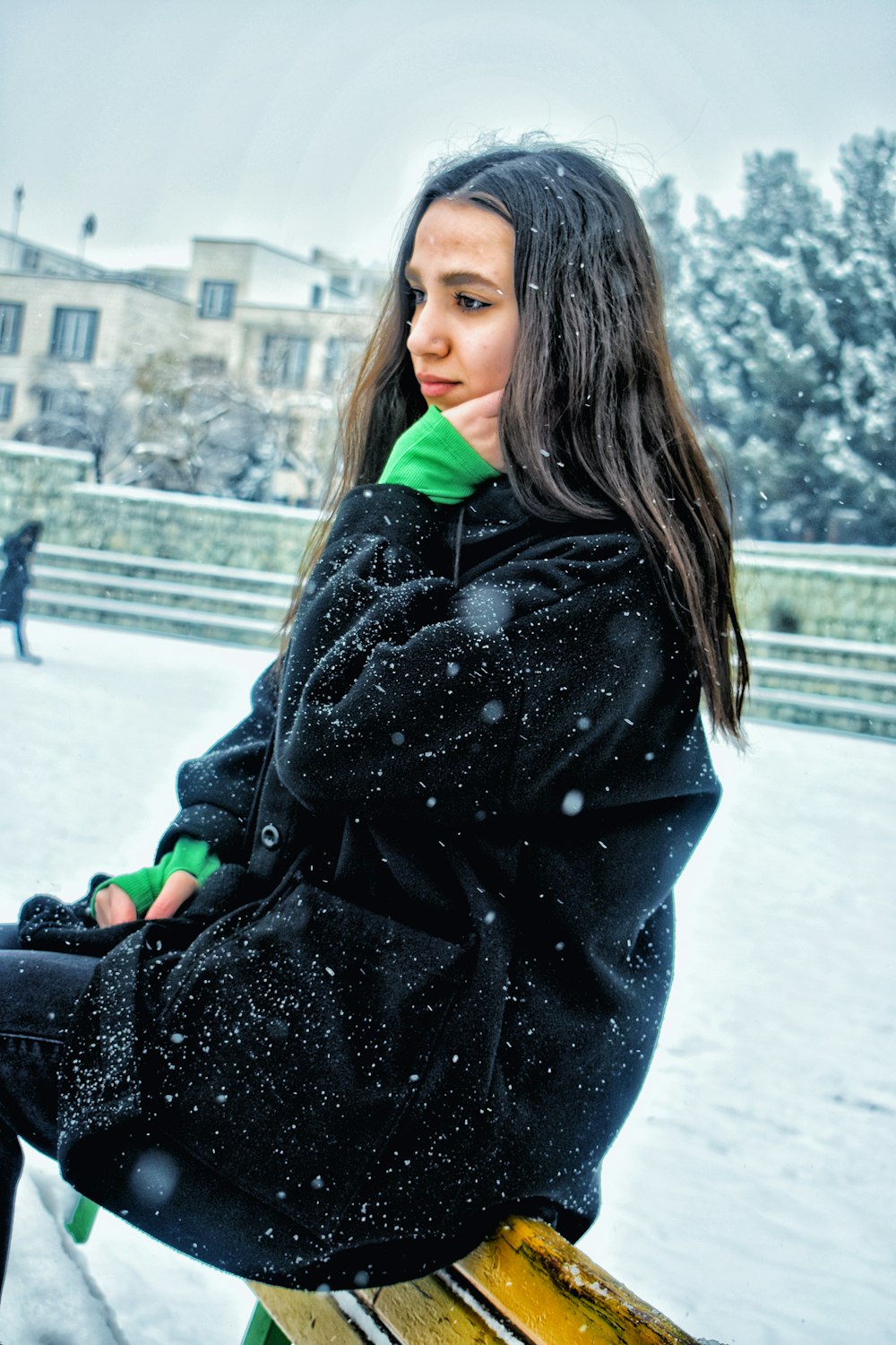 a woman sitting on a bench in the snow