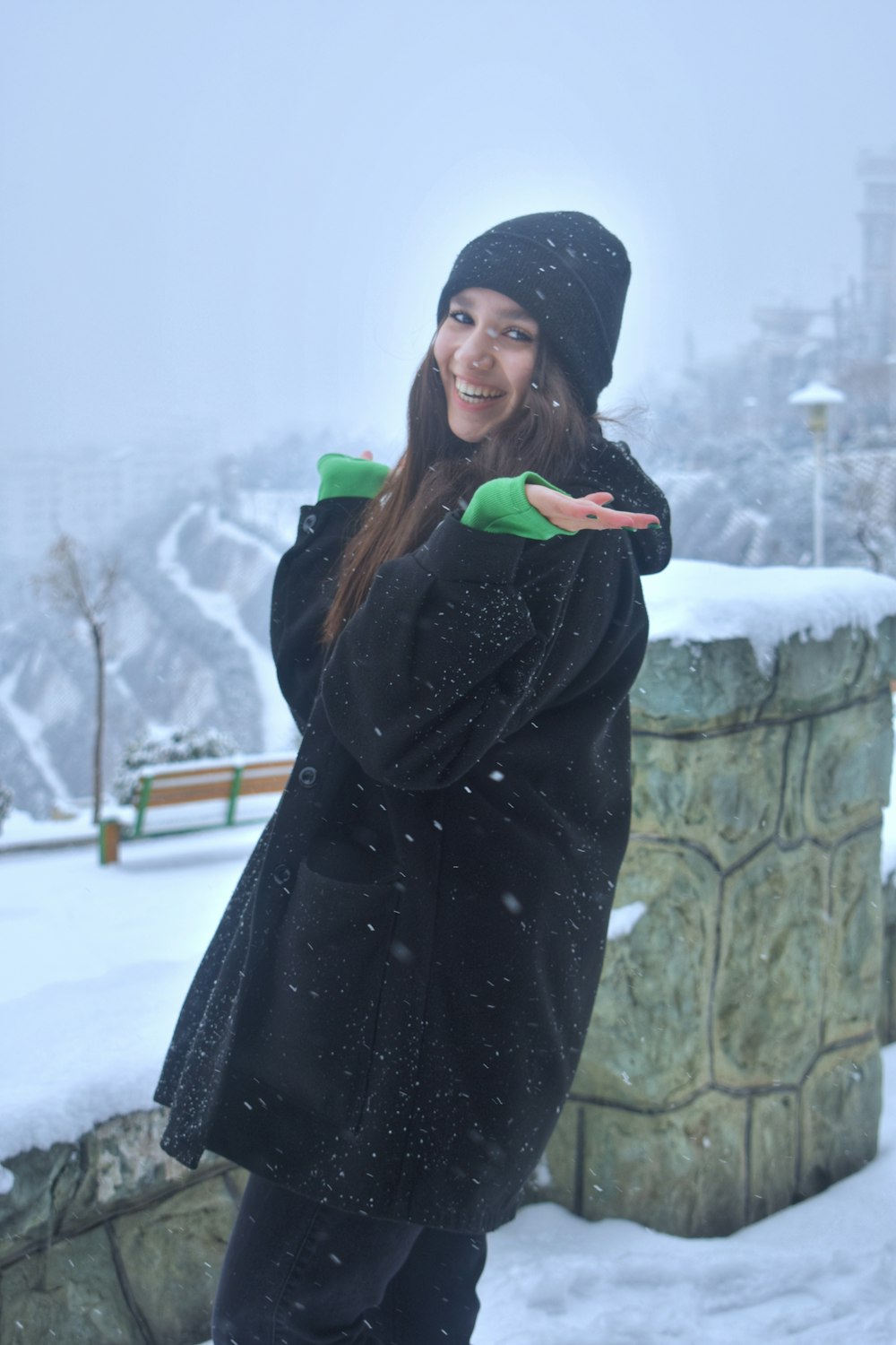 a woman standing in the snow with her arms out