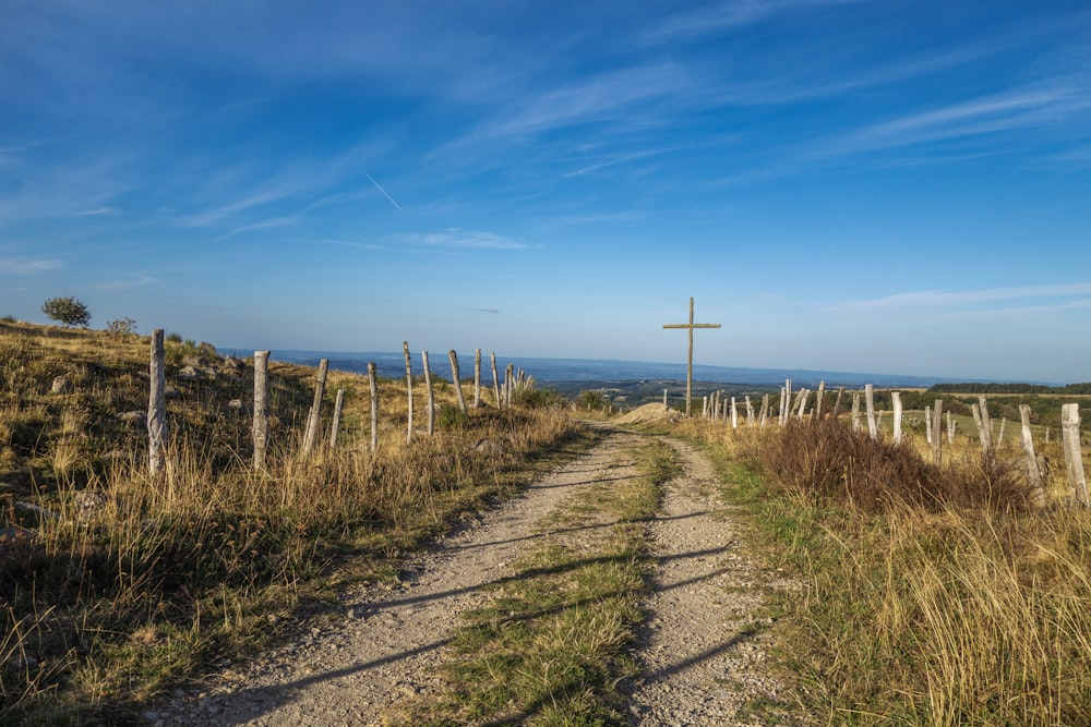 a dirt road with a cross on top of it