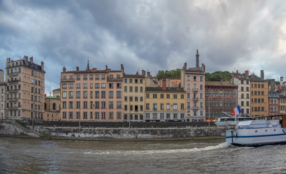 a boat traveling down a river next to tall buildings